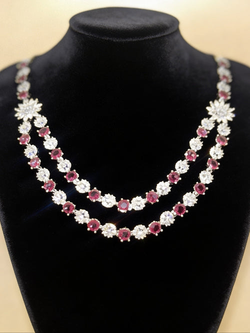 Double-strand necklace featuring ruby red stones and white American diamonds with a sunburst centrepiece. Elegant bridal jewellery for weddings, sangeet, and special occasions.