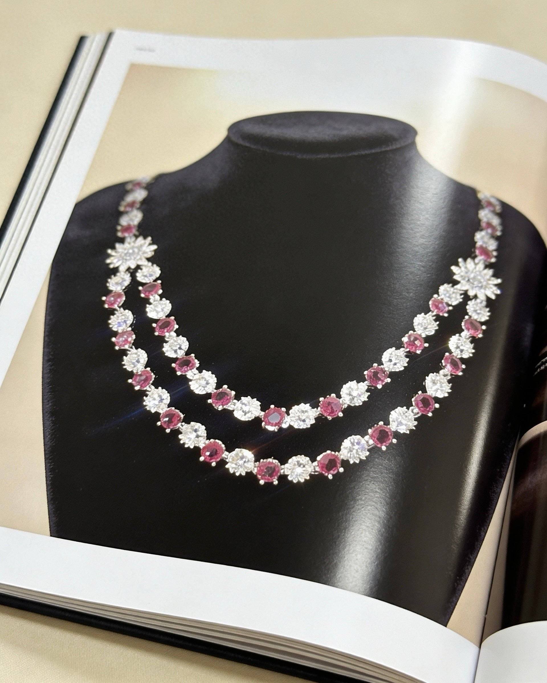 Double-strand necklace featuring ruby red stones and white American diamonds with a sunburst centrepiece. Elegant bridal jewellery for weddings, sangeet, and special occasions.