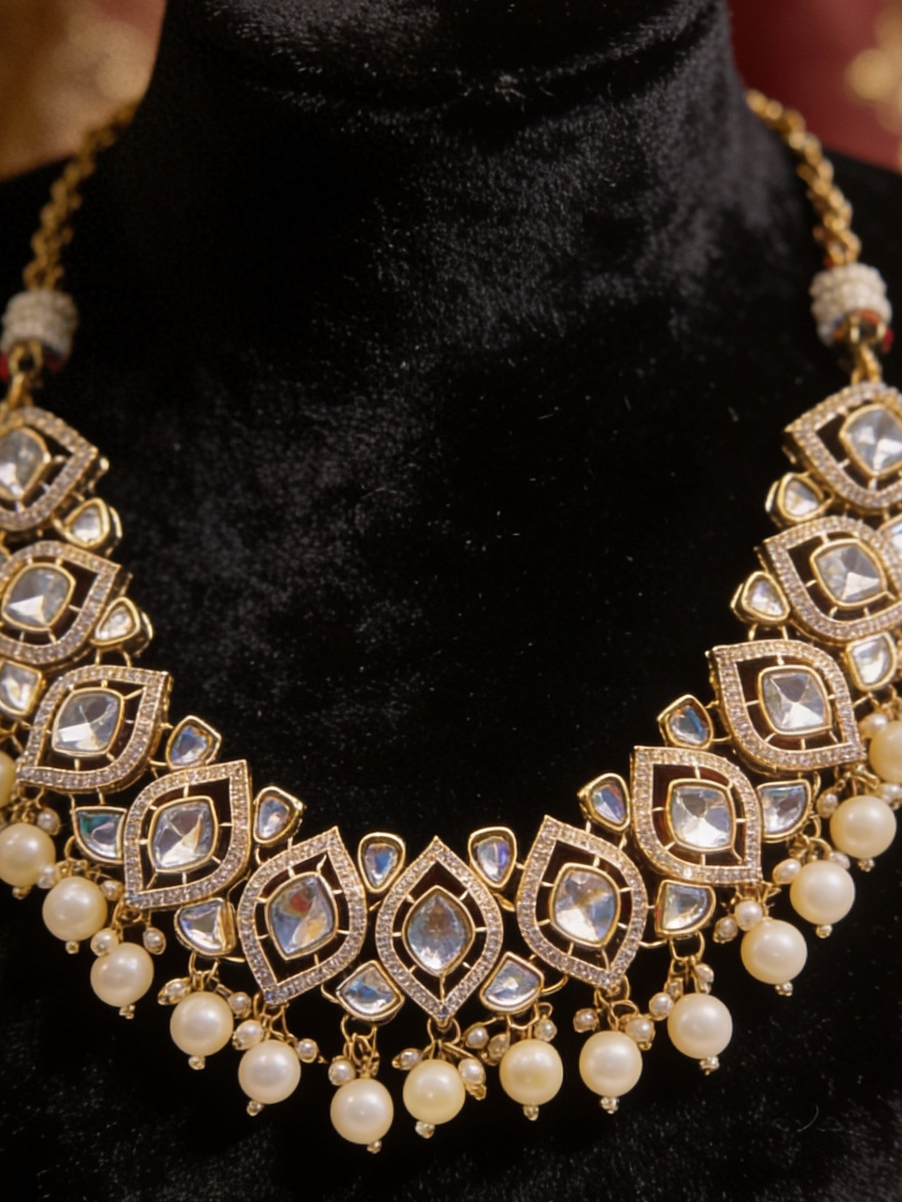 Ornate necklace with pearls and crystals on a black velvet stand