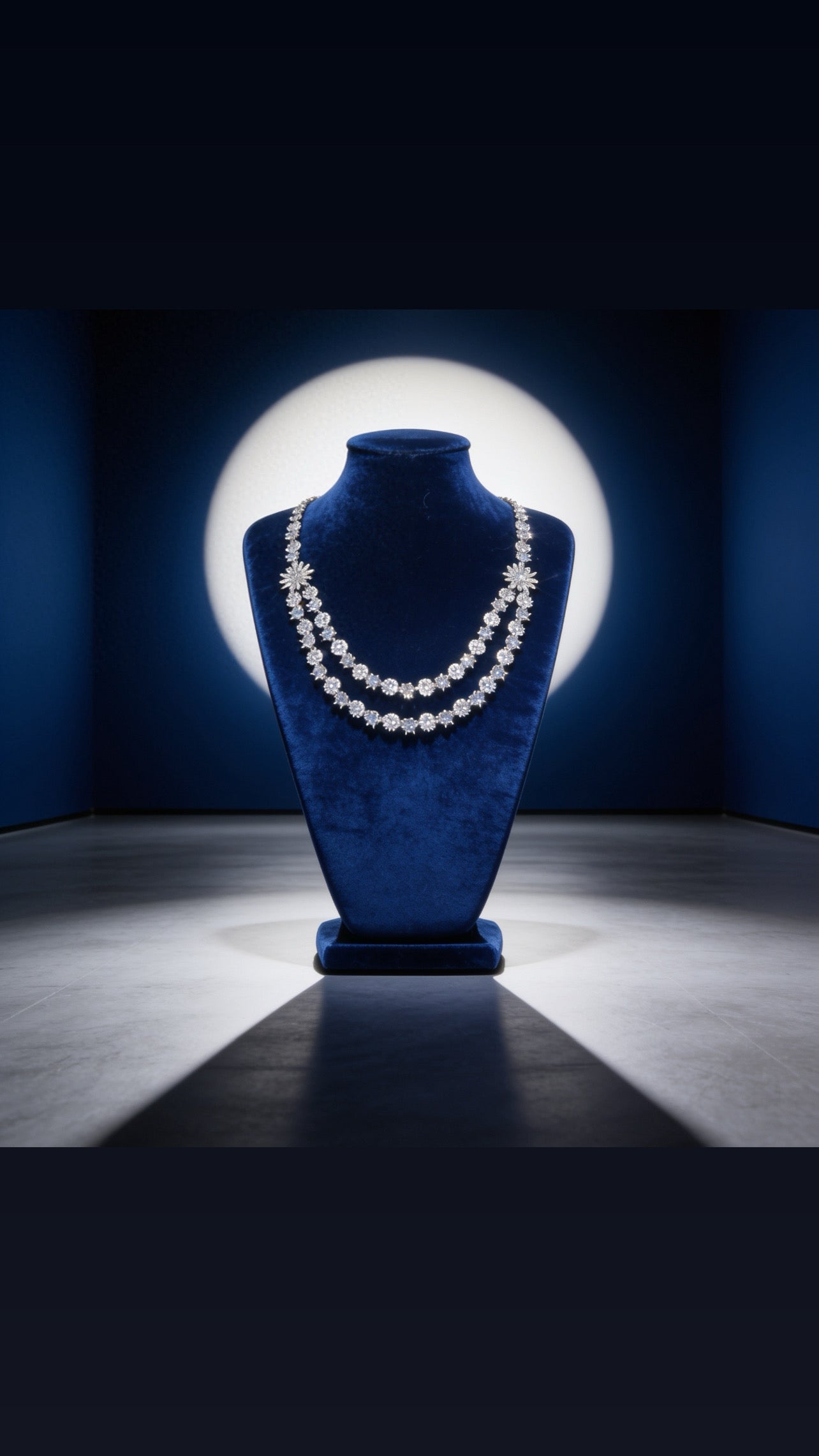 Diamond necklace on a blue velvet mannequin bust against a dark background